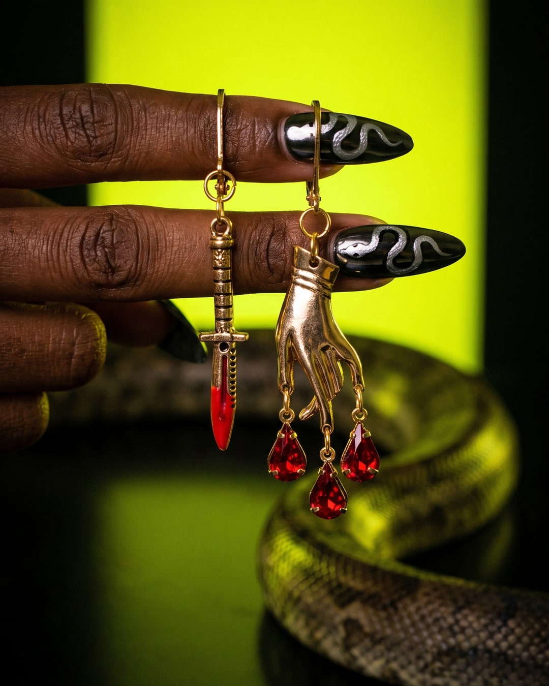 Dagger and Bleeding Hand Earrings, Mismatched Gold-Tone Drops, Dark Feminine Gothic Jewelry, Red Teardrop Accents. Photograph 1 of 4.