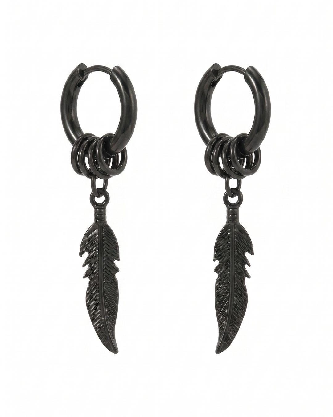 Close-up of feather charm huggie hoop earrings showing grooved feather drop and stacked rings