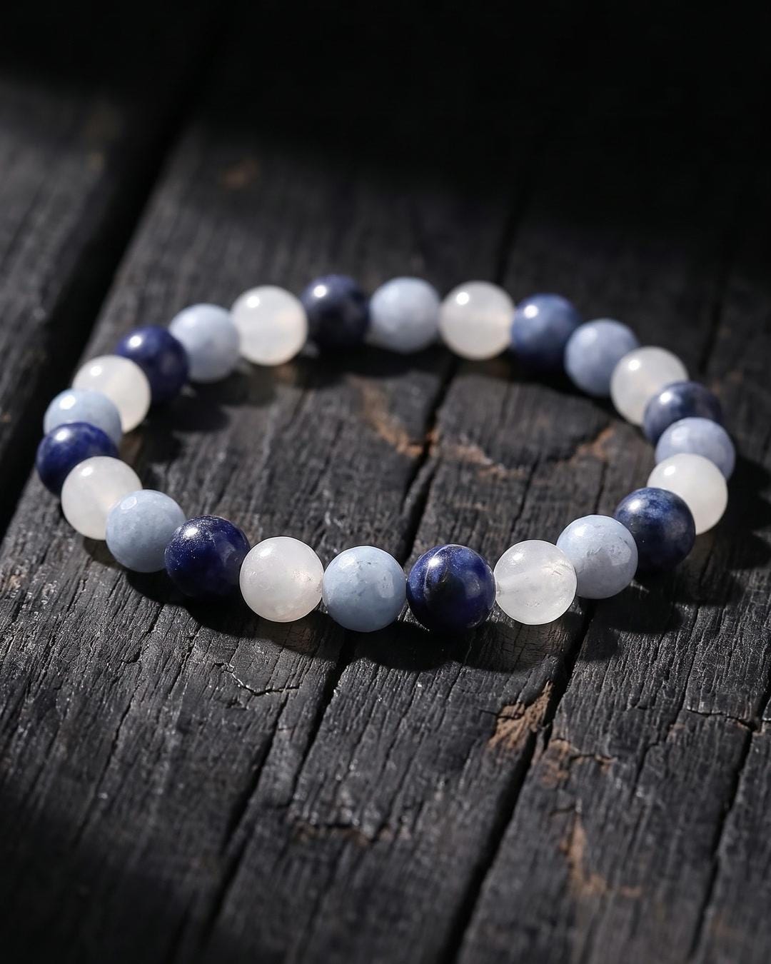 Celestial whimsigoth beaded bracelet in navy, powder blue and milky white on a flat surface
