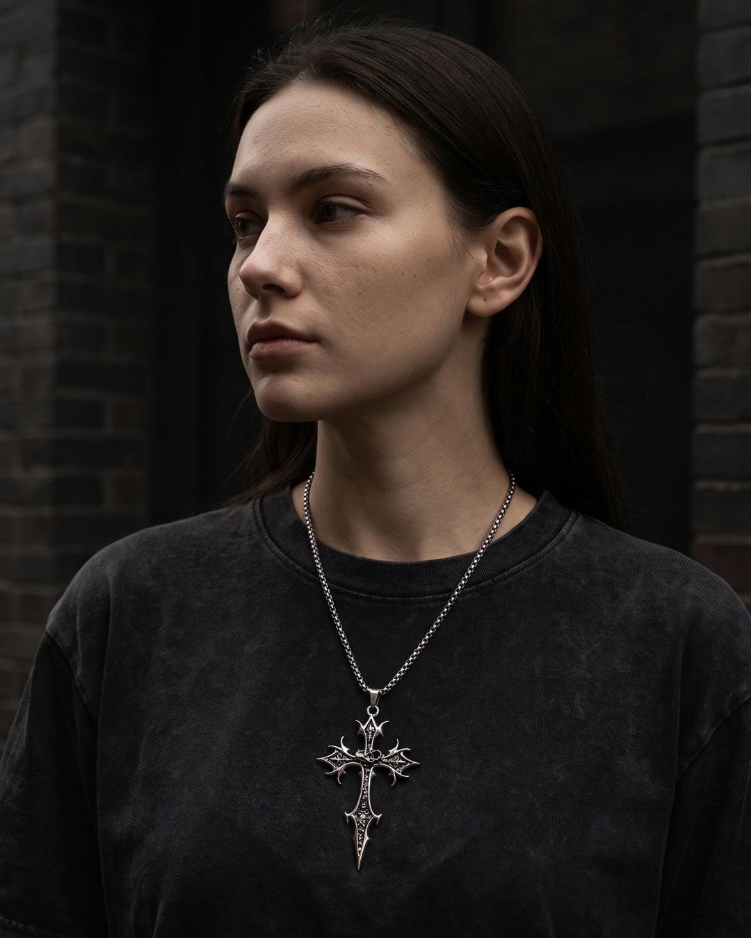 Gothic cross necklace worn long over a black slip dress showing full pendant length