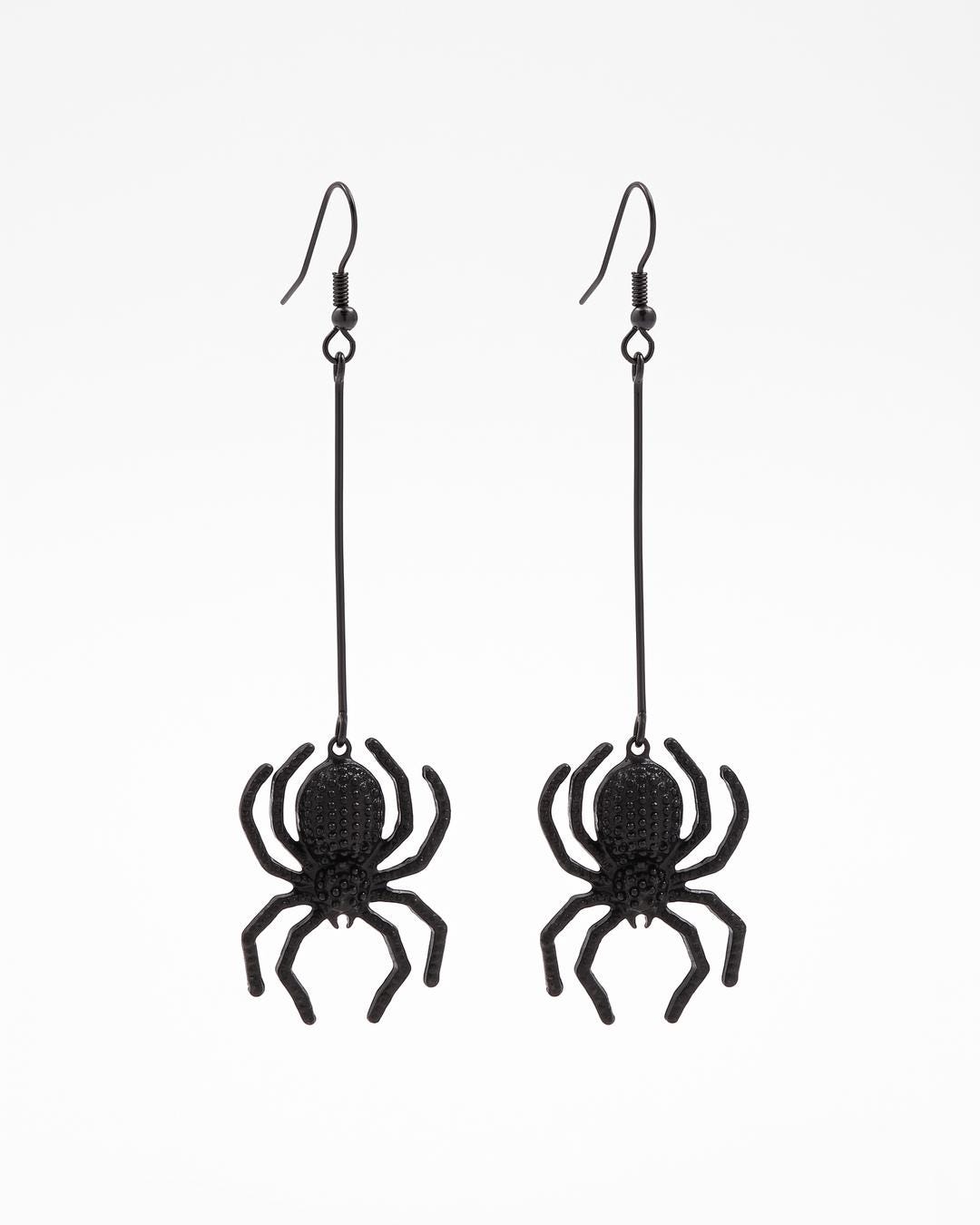 Close-up of matte black gothic spider drop earrings showing textured spider body and bent legs on a bar link