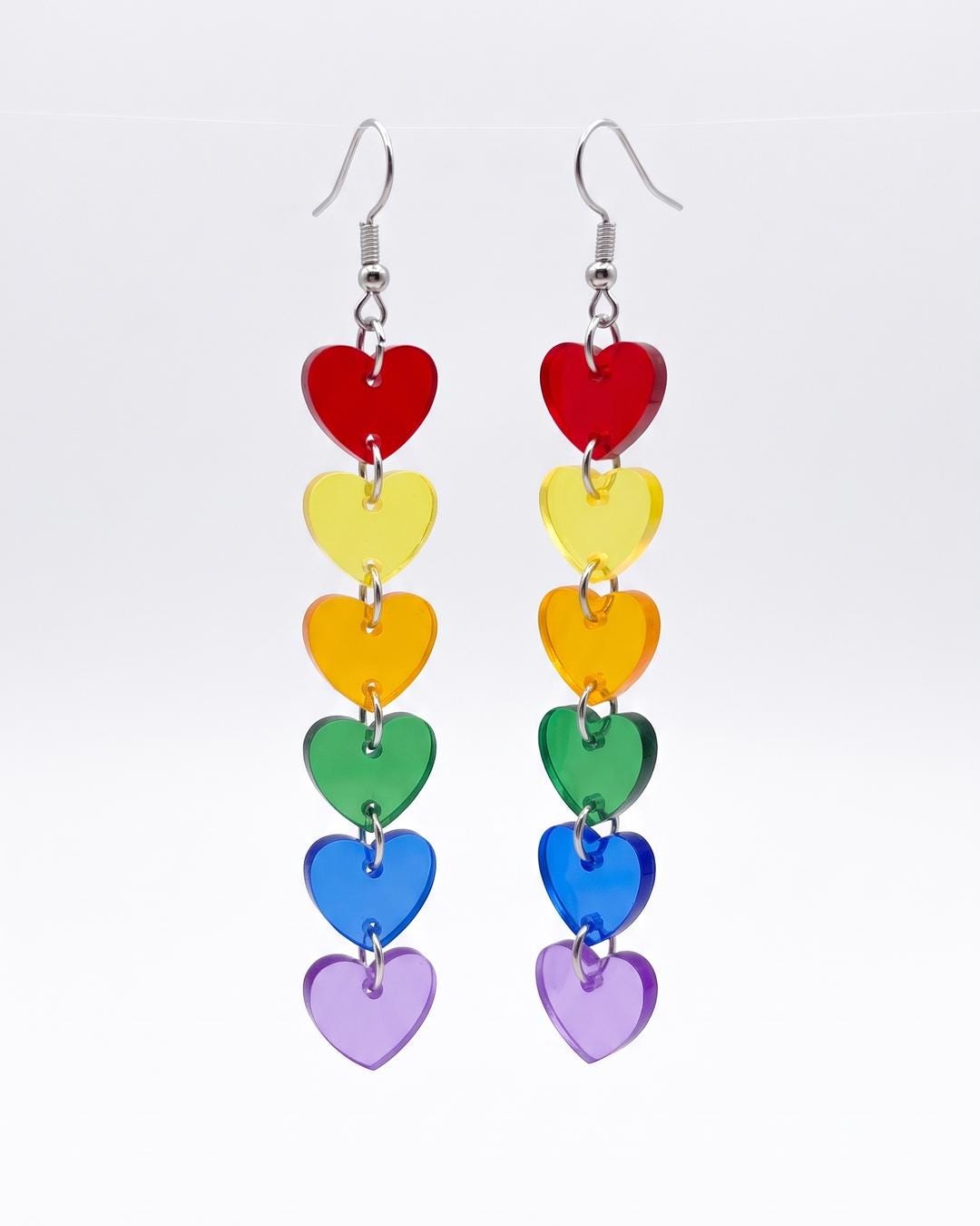 Close-up of rainbow heart drop earrings showing six translucent hearts in red, orange, yellow, green, blue and purple.