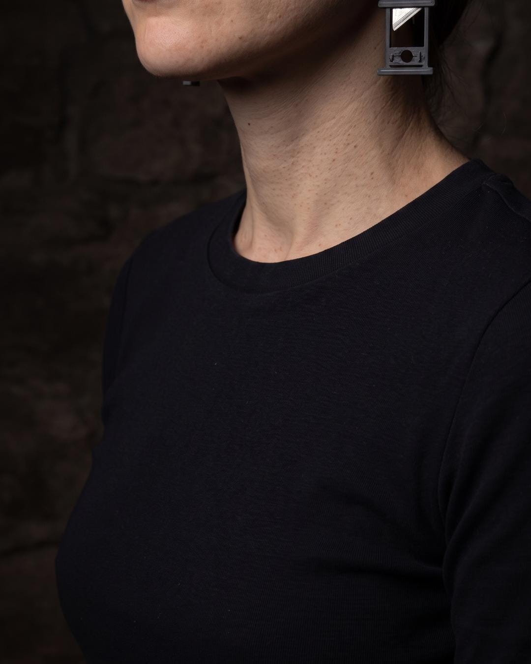Vintage guillotine drop earrings worn with hair pinned up, blade detail visible against the neck